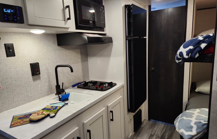 A well equipped kitchen with a 2 burner stove, micro-wave and refrigerator.  Microwave must be on shore power.