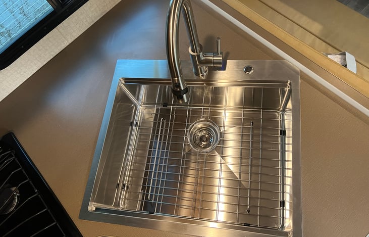 New large stainless working sink with strainer, dish drainer, cutting board, and a quality pull down faucet.
