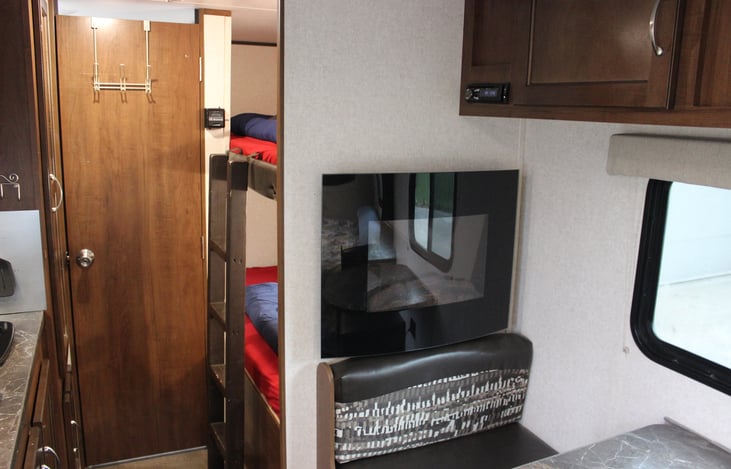 Twin beds behind kitchenette with electric space heater (with remote controlled deluxe faux wood fireplace lighting - fancy)