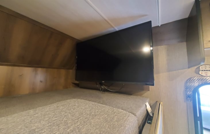 Overhead sleeping/storage area w/TV.