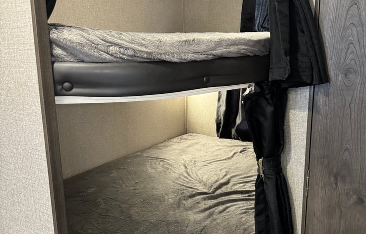 Two full size bunks containing separate lights, windows, and privacy curtains.