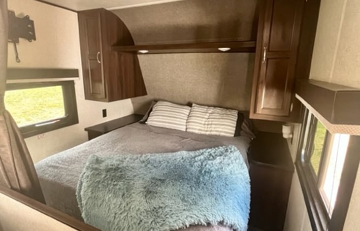 Master Bedroom, queen bed, shelving and cabinets. 
Curtain closes off room for privacy