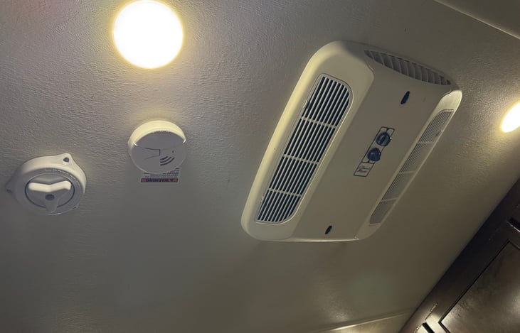 Smoke detector and fan located on ceiling in main living area.