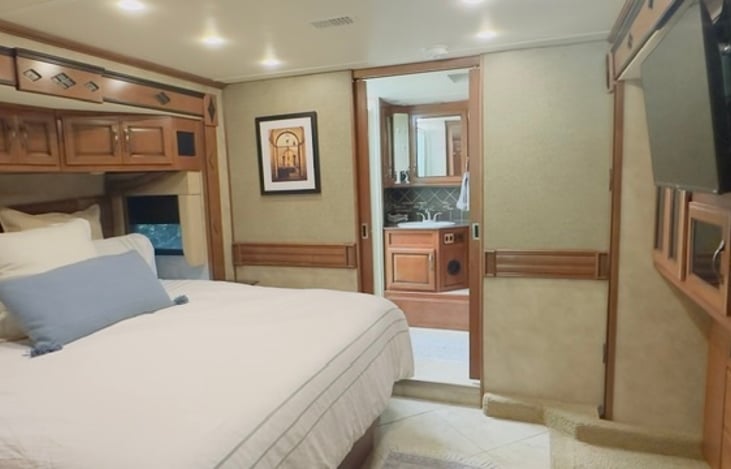 The master suite includes a private bath separated from sleeping area by French sliding doors. Enjoy a spacious area with shower, toilet, vanity and linens.