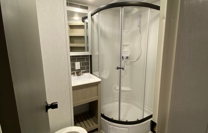 Bathroom.  Towels and a bath mat are stored under the sofa in the living area.