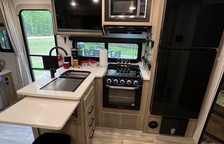 TV, Microwave, stove, oven, sink, fridge/freezer, fold out extra counter space, fully equipped