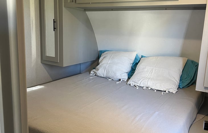 Camper queen bed includes two sets of bedding clean and ready for you.