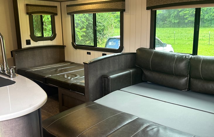 Photo showing kitchen table and sofa converted for sleeping.