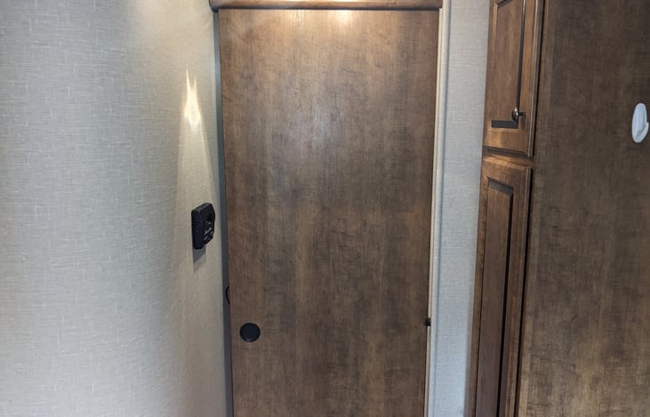 Door on either side of TV in living area to offer privacy for front bedroom.