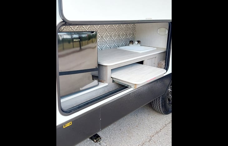 Outdoor kitchen: TV/Cable hook up, 2-plug electrical outlet, mini refrigerator, hot/cold water sink, slide-out counter top