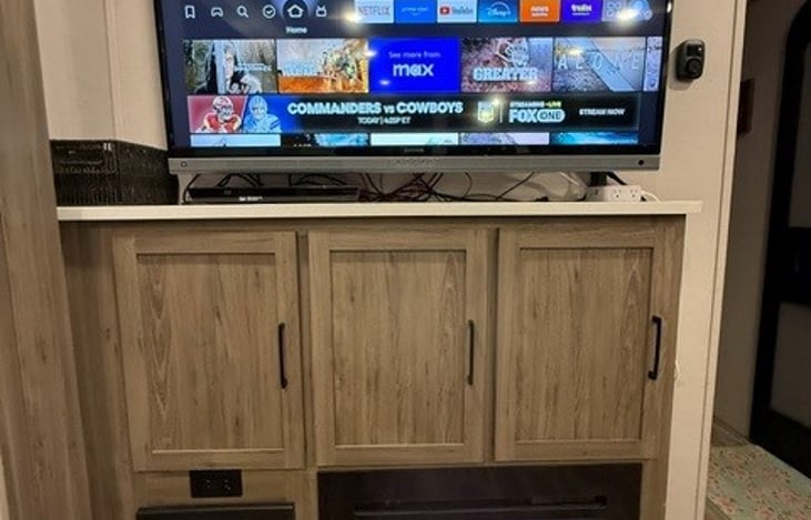 Entertainment Center. Large TV (Included Firestick), DVD Player, built in electric RV Fireplace.