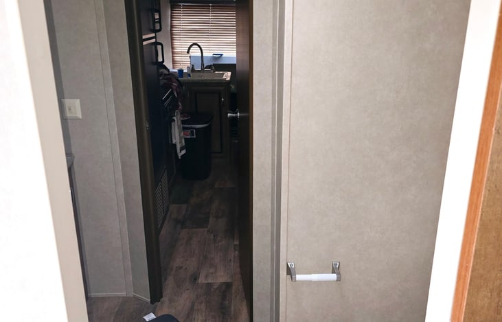 The view from the bedroom extends through the bathroom and into the heart of the main living area. You can shut the bedroom door for privacy or leave it open to partially see through the rear window