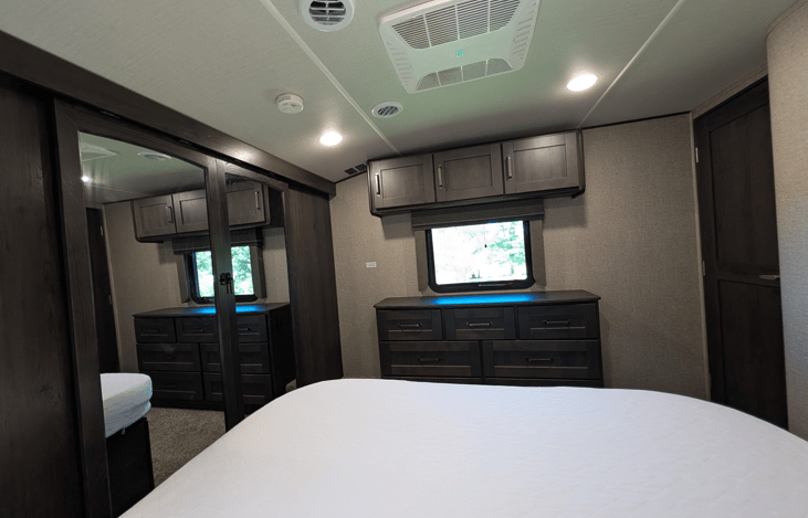 Gourmet galley & rear den retreat! Includes a 12 cu ft fridge, pantry, stove/oven, dual sofas, theater seats, 50" TV, electric fireplace, and 3 slides for spacious high-end living.
