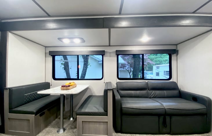 Huge slide out with dinette (can convert to bed) and sofa bed with footrests.