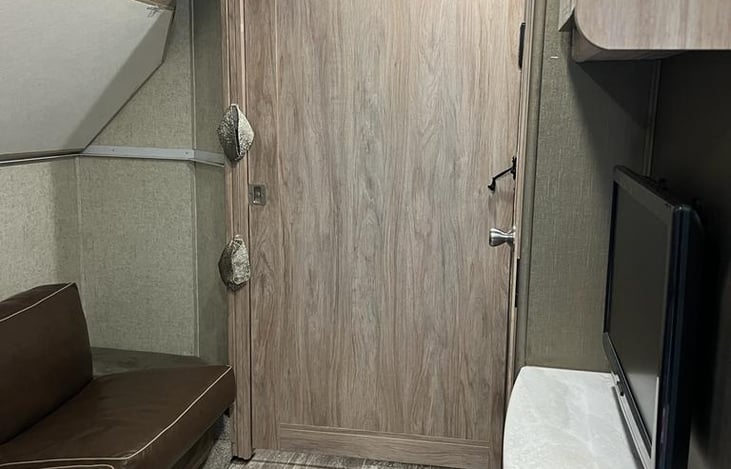 Bunk area with master bedroom door closed and top bunk put up.