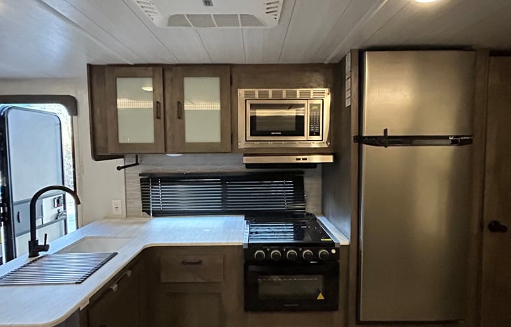 kitchen area- sink, stove and refrigerator.