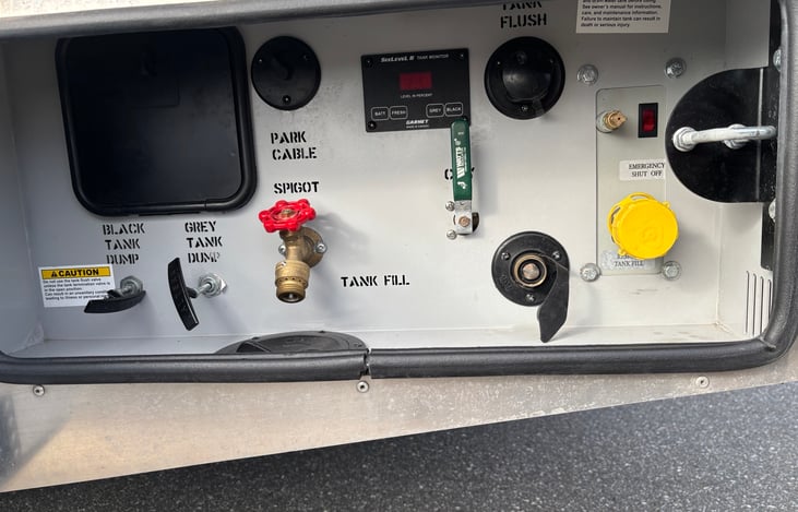 All located in one central area! Here is were you drain the tanks, connect fresh water, cable and refill LP gas tank. Also has an "outdoor shower" hose.