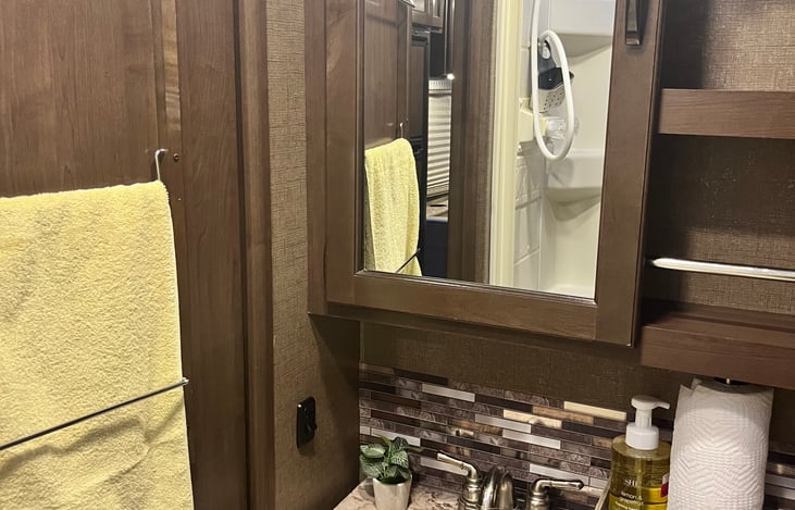 Bathroom cabinets and storage. Towel rack on bathroom door.