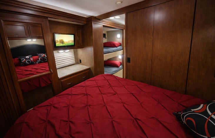 A beautiful queen-size bed and Smart TV are located in the private master bedroom.