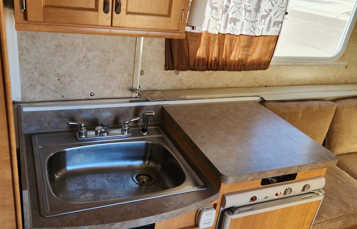 Running kitchen with fridge that runs on grid electric, battery, or propane.