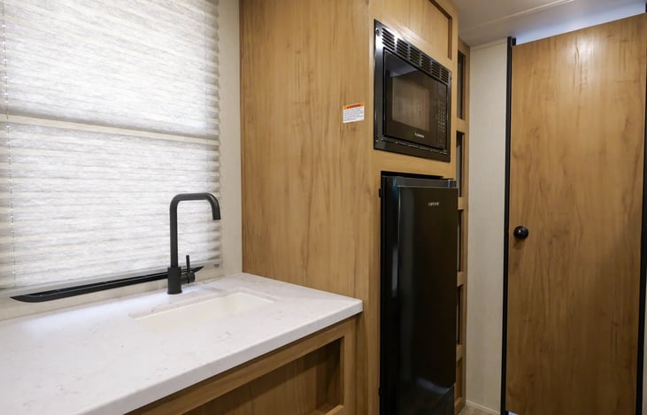 Kitchen area with bathroom entrance  near by.