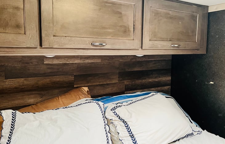 Queen bed and cabinets above bed