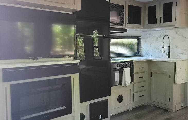 Kitchen and inside entertainment center with fire place, large refrigerator!