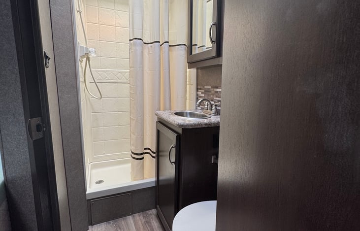 Bathroom with vanity, shower, medicine cabinet and toilet