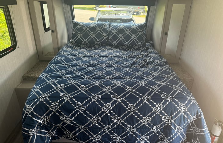 Walk-around queen size bed, hanging closets on both sides and large storage cabinet overhead