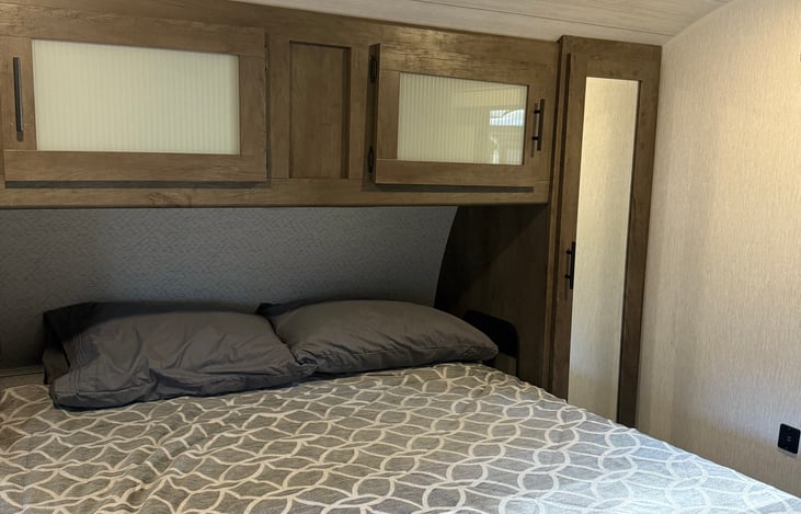 Private master bedroom, has shelves around bed and also a closet.