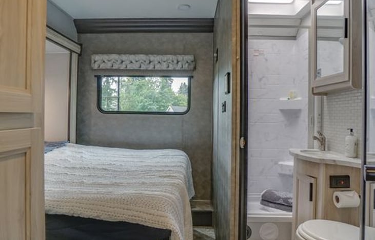 Master bedroom has a privacy curtain that closes by bathroom wall.