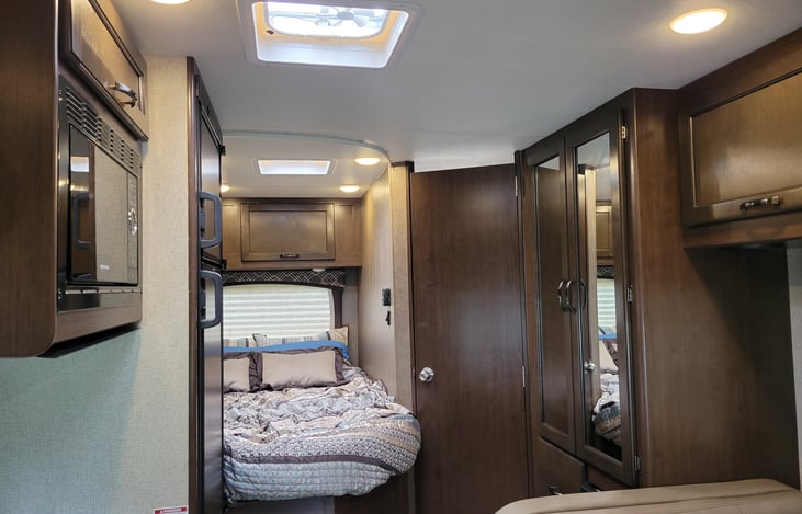 View of the Bed, Bathroom, and Closet standing by the table.