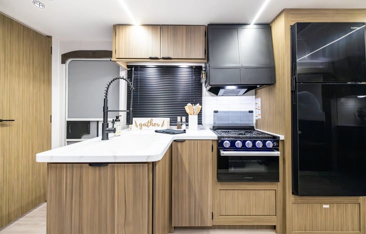 Kitchen with overhead microwave, stove and oven. Spacious fridge. Deep country sink, fold out trash can. Stocked with kitchen supplys.