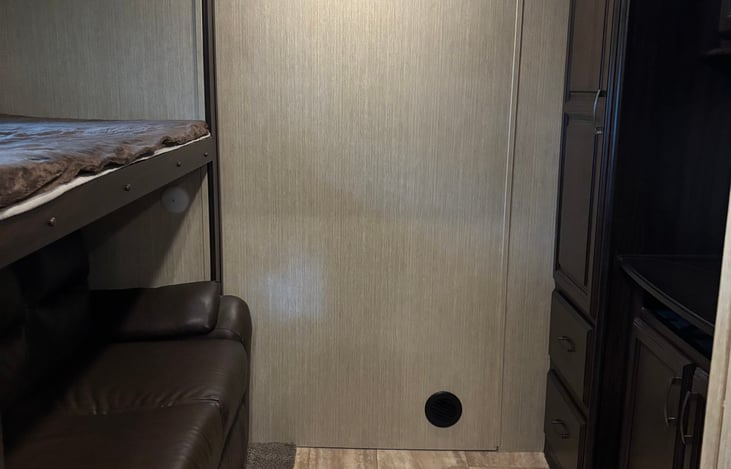 Bunk room beside the kitchen has a top bunk for 1 and a sleeper sofa for 2, with lots of storage for all their needs