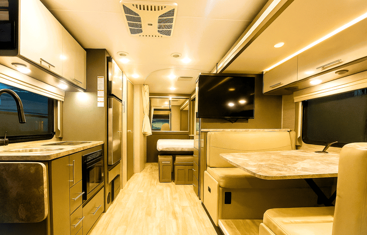 Spacious motorhome interior with full kitchen and dinette – RV rentals near me in SoCal.