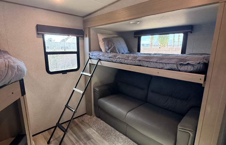 Bunkhouse twin overhead bed with ladder and a pull out sofa underneath.