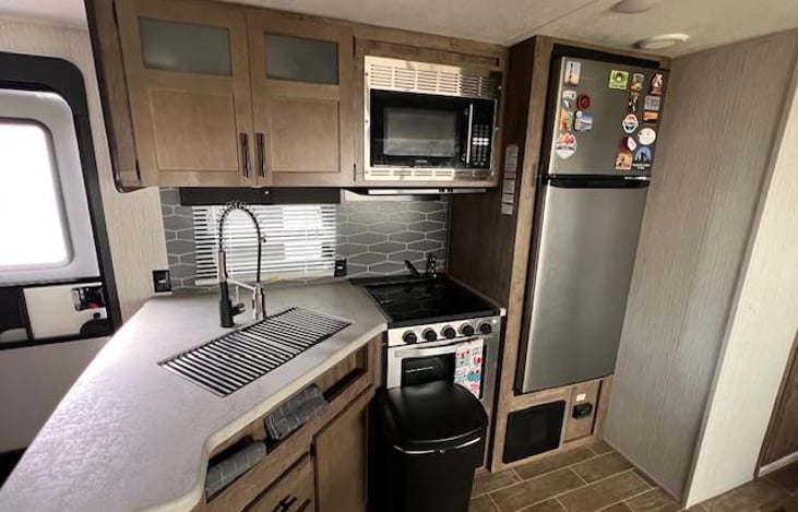 Kitchen with refrigerator, sink, stove, microwave and cabinets for storage