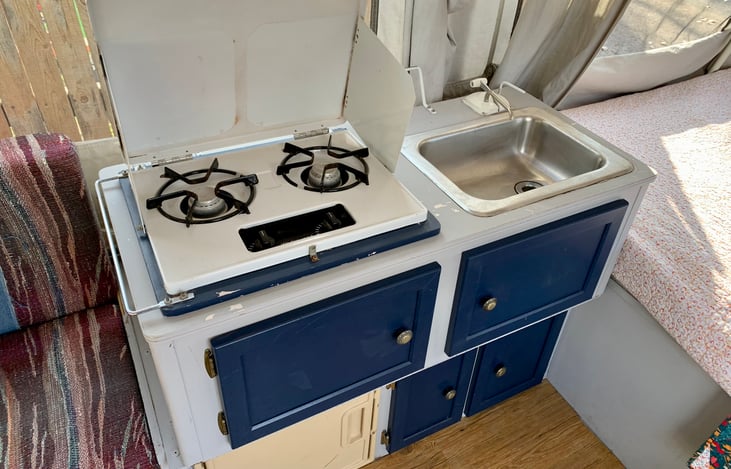 Propane stove, small sink, and ice box for your convenience.