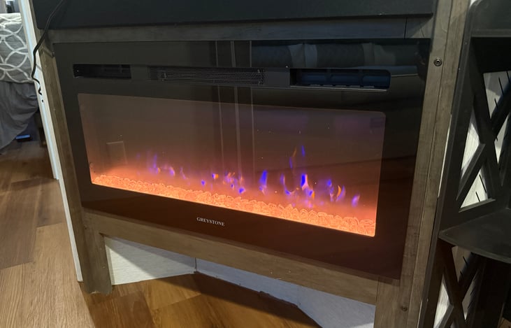 Fireplace located under the entertainment system.