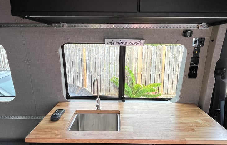 Appliances include a sink/faucet, large fridge, microwave, and induction cook top.