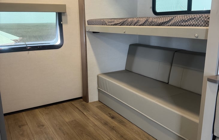 Rear twin bunk street side with sofa that folds out into a queen (short) bed