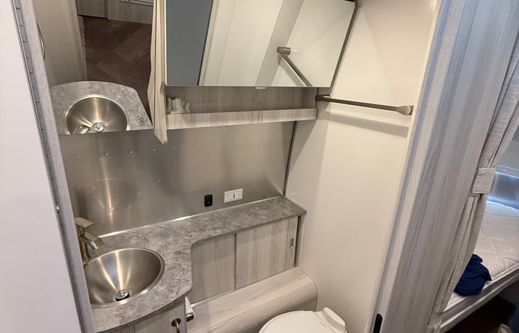 The lavatory includes the toilet and sink. Plenty of mirror.