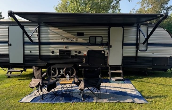 Camper includes 4 camp chairs, card table, camper mat, and tripod grill.