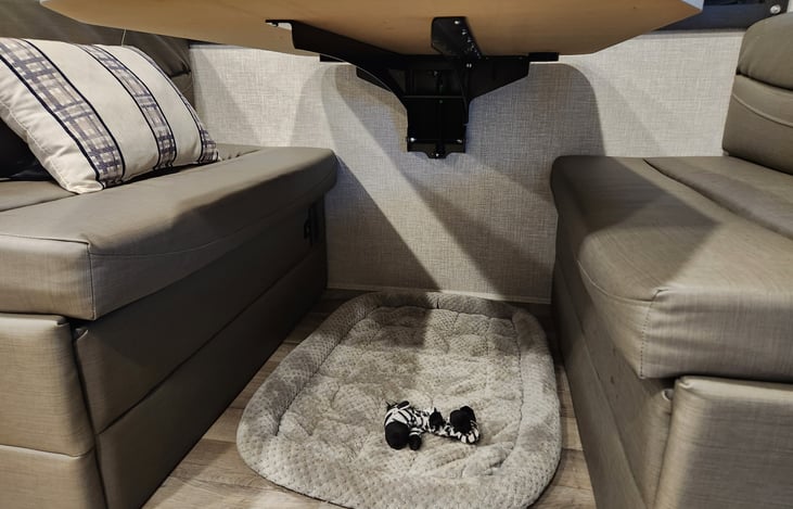 Dinette table drops to full-sized bed, electrical outlets under table and storage underneath bench seating