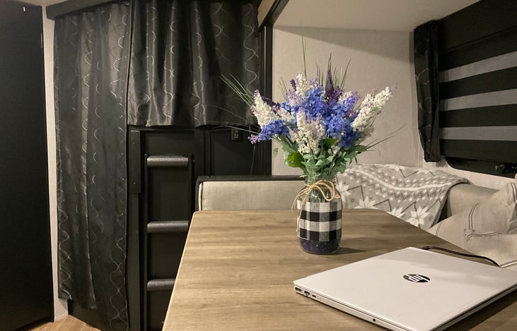 Dinette table shown with Bunk Beds privacy curtains drawn. (Laptop not included in rental :-D)