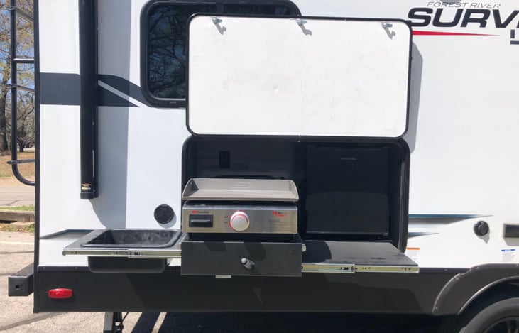 Complete outdoor kitchen with cooktop, wash basin and water hose, and mini fridge. Perfect for those sunny days!