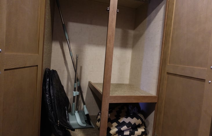 Large storage closet in living room next to couch