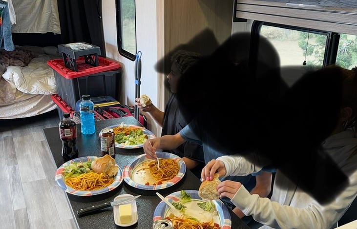 There’s a free standing table that is stored under bunk mattress to be used in front of the bench that folds up and turns into a bed