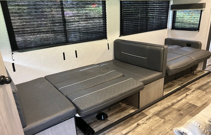 View of dinette and sofa setup in bed configuration.