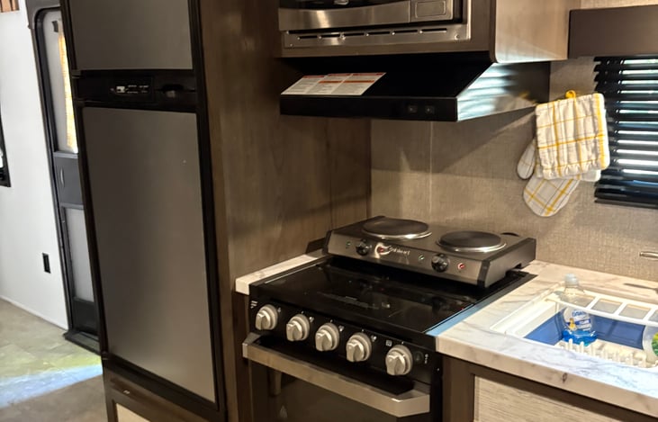 Propane stove & electric burners. We prefer the electric burners they cook faster and can be more self inside and out.